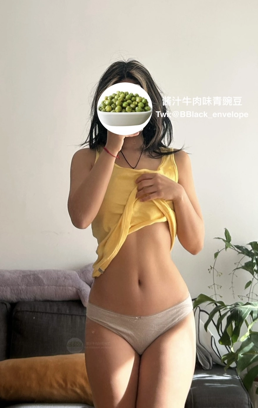 穿着黄色衬衫的女人拿着一碗草莓。