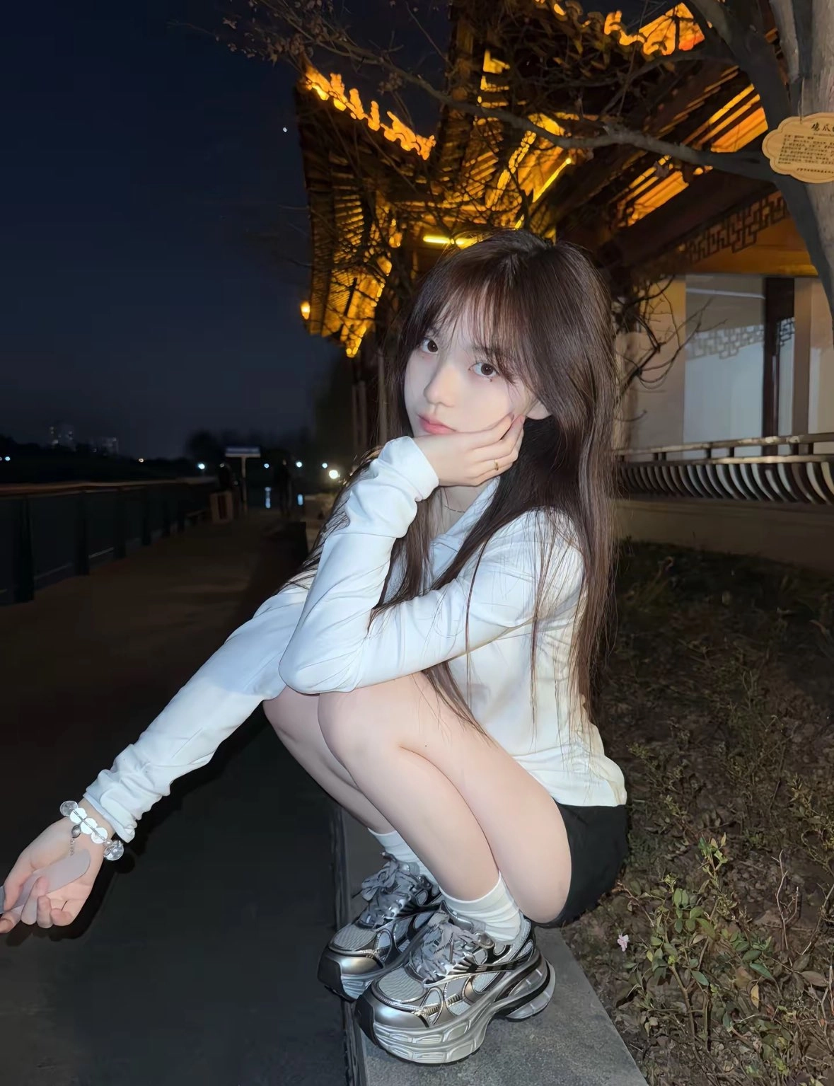 女人坐在一个凳子上,她的腿交叉。