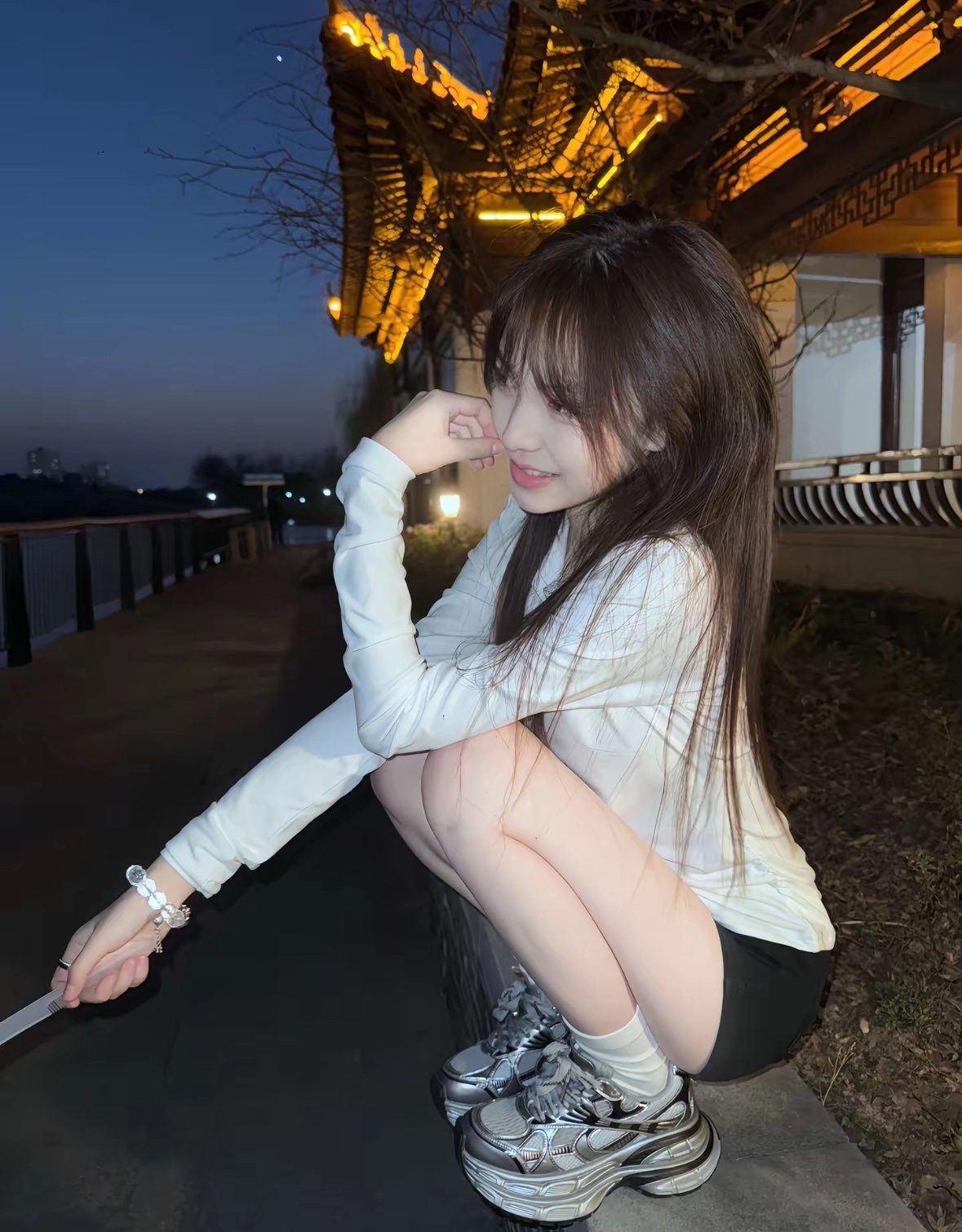 女人坐在一个凳子上,她的腿交叉。