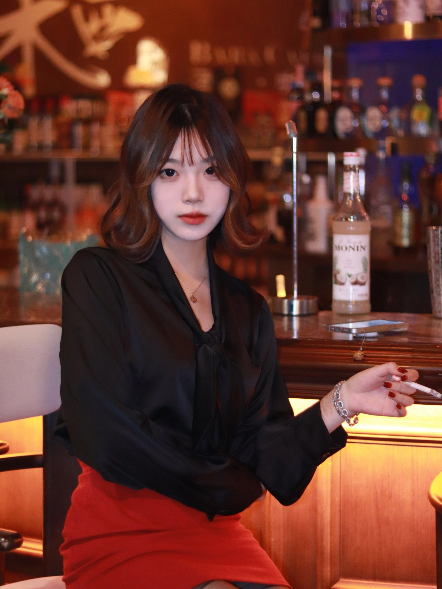 红头发和黑衬衫的女人抽一支香烟。