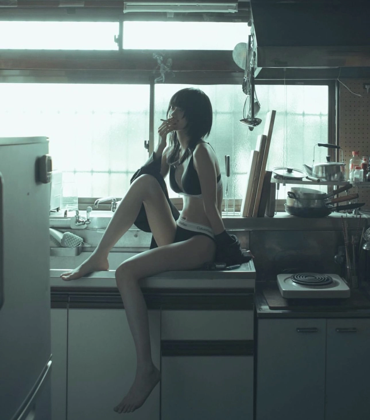 女人在厨房里抽一支烟。
