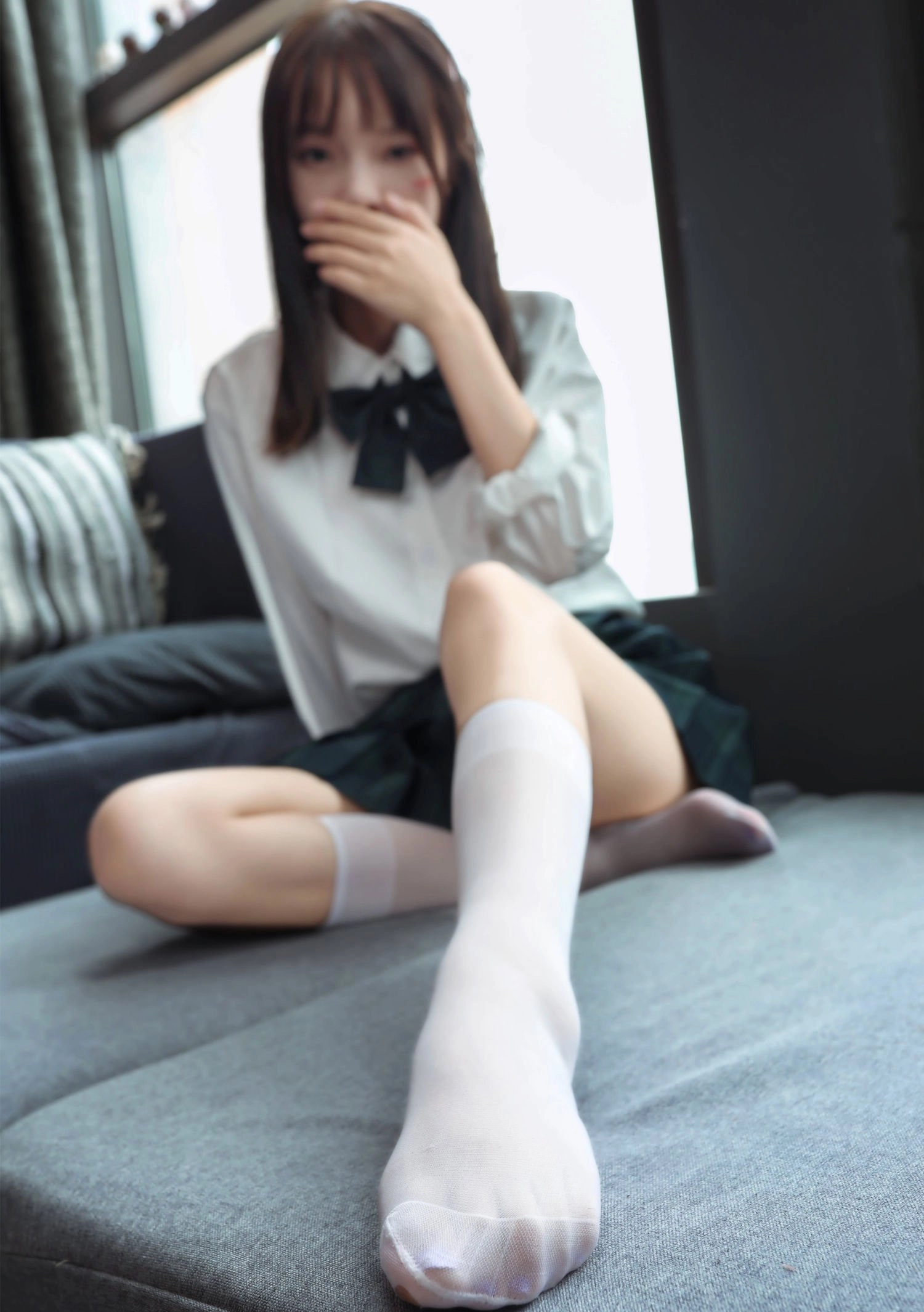 穿着白色衬衫和黑色衬衫的女人坐在沙发上。