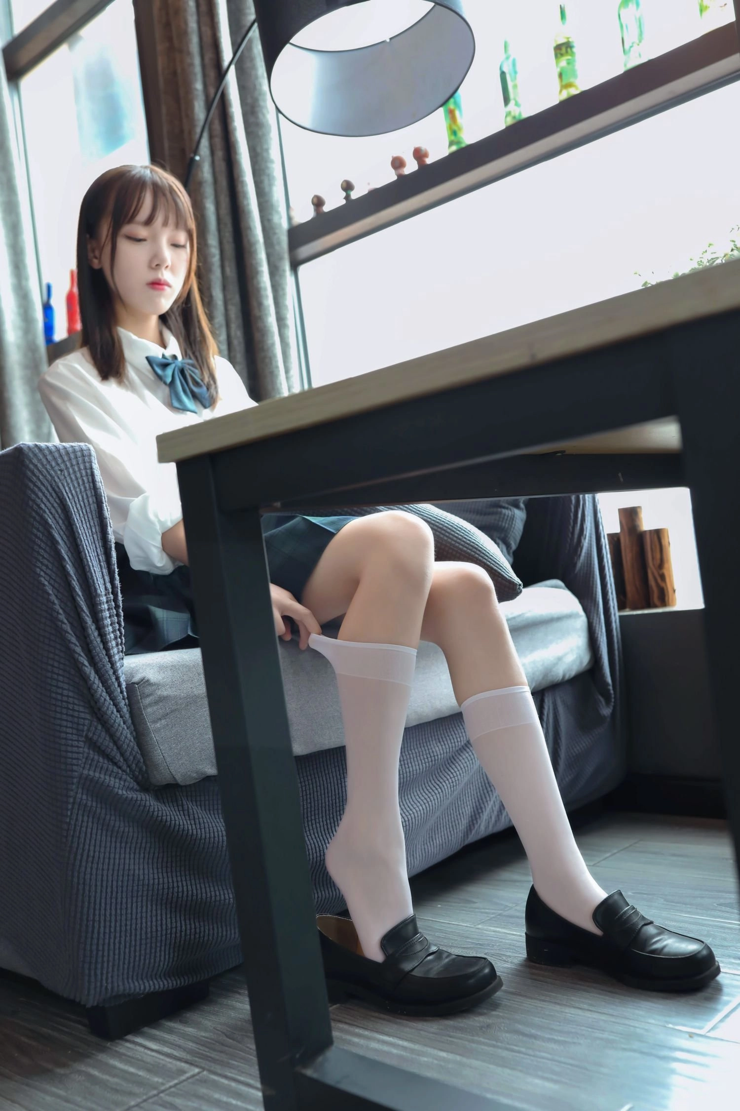 穿着白色衬衫和黑色衬衫的女人坐在沙发上。