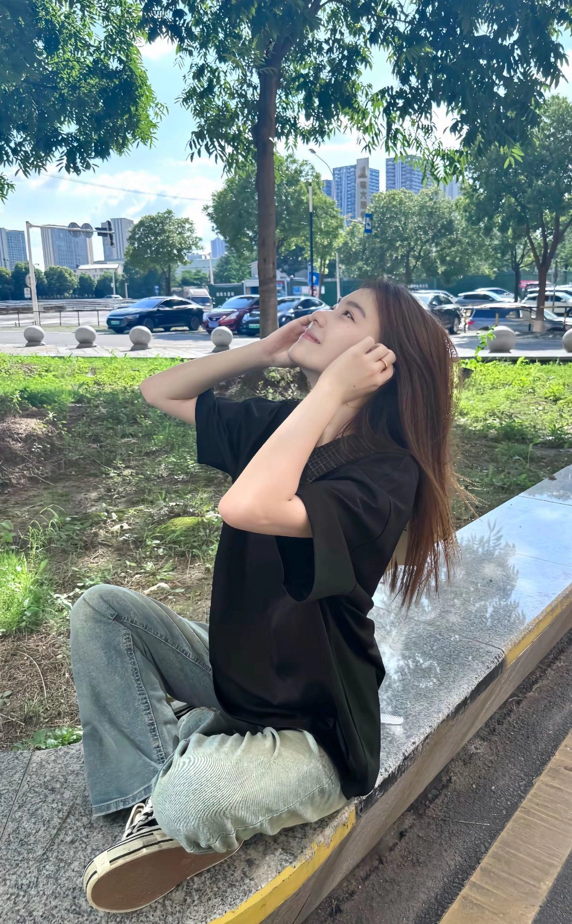穿着黑色衬衫的女人坐在一个凳子上。