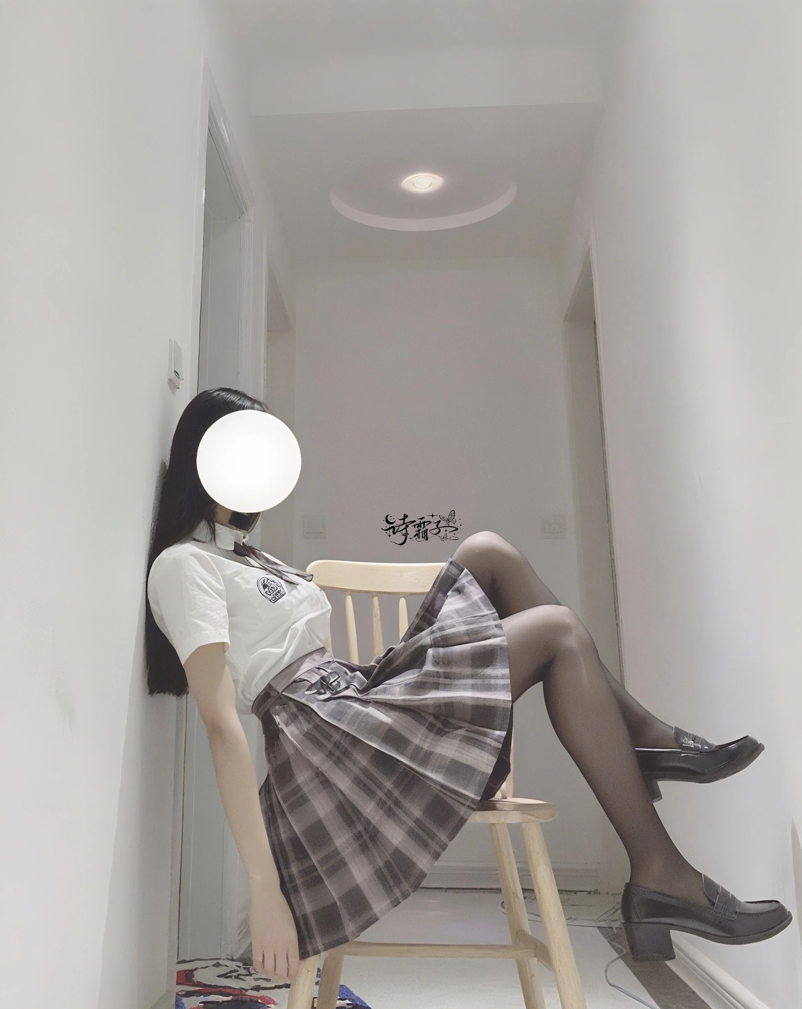 一位穿着白色衬衫和一件白色裙子的女人坐在椅子上。
