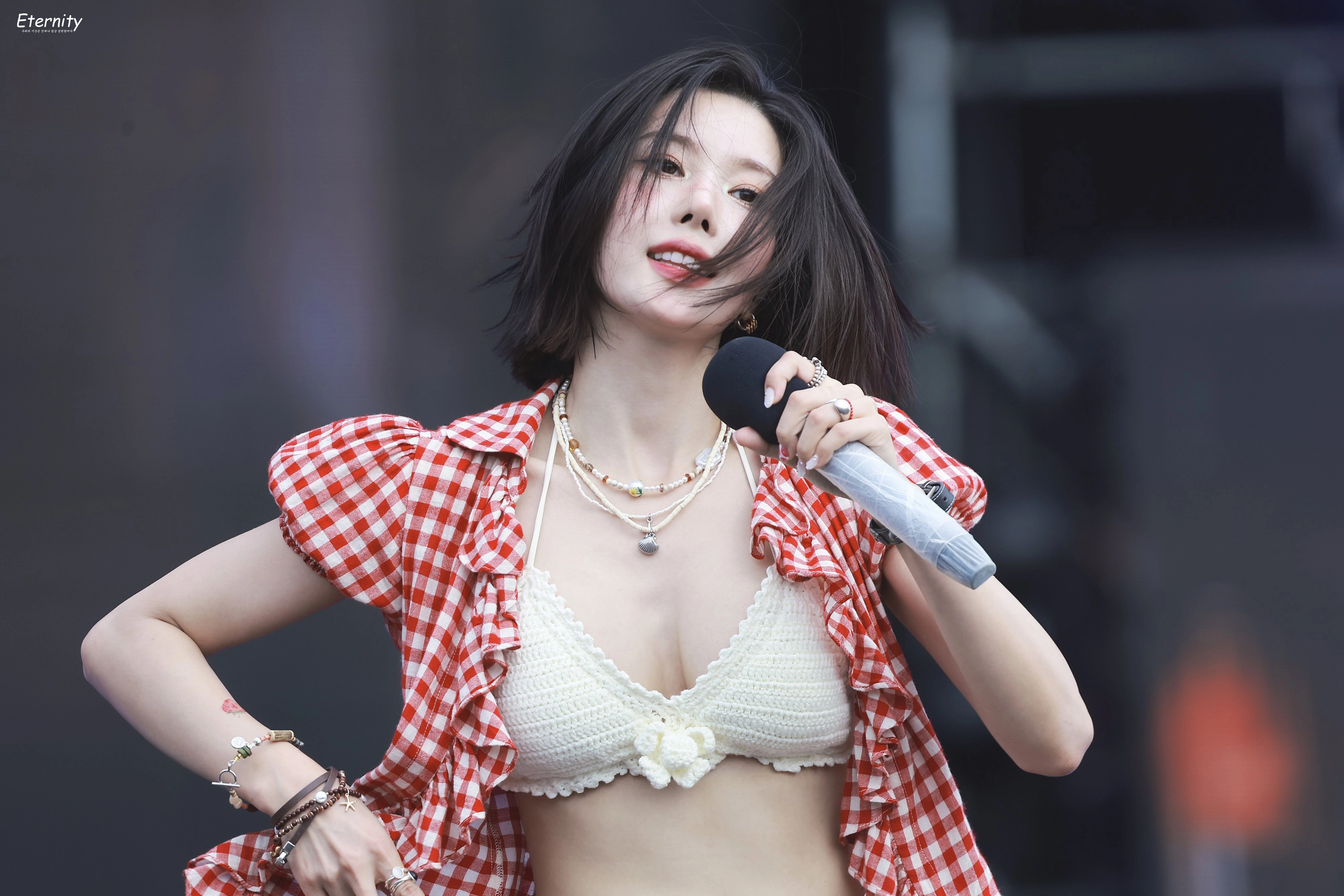 穿着白色衬衫和项链的女人在麦克风里说话。