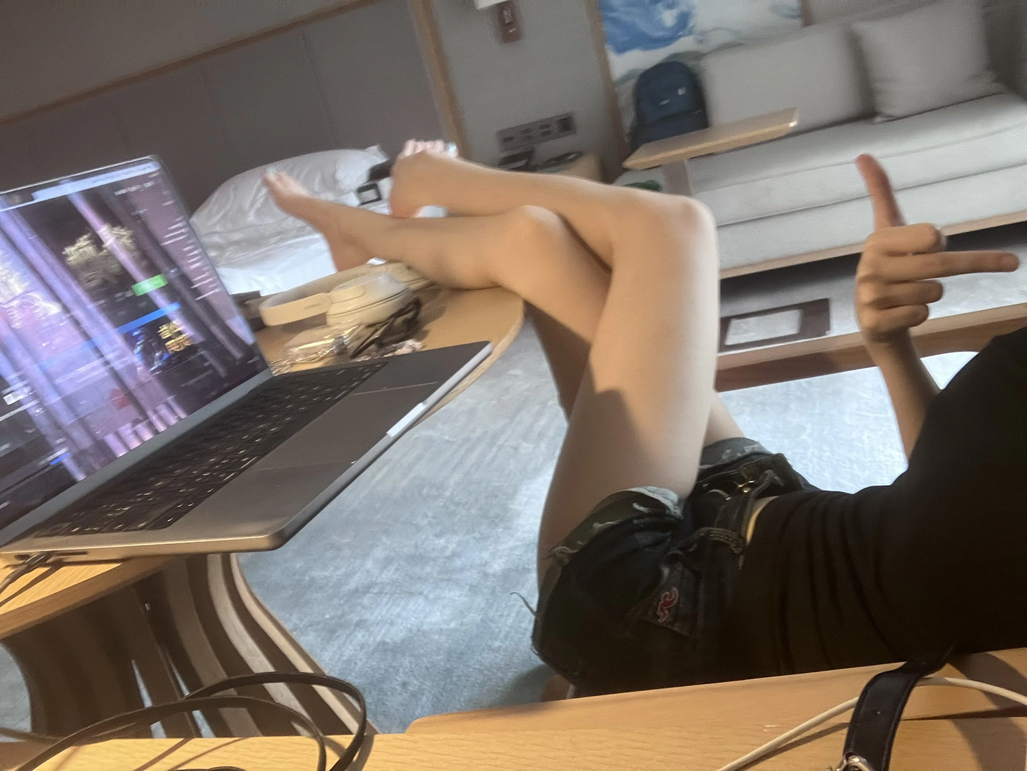 女人坐在沙发上,举起拇指。