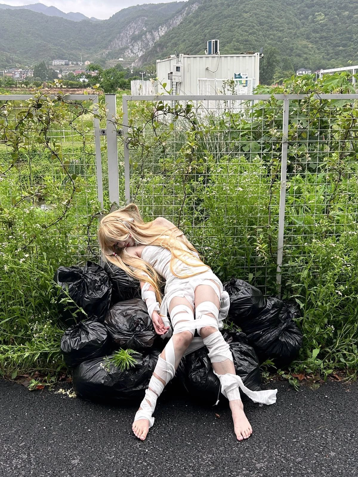金发的女人躺在一堆垃圾上。