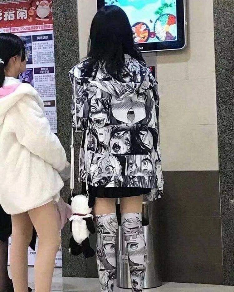 两个女孩站在海报前面,上面有一个卡通人物。