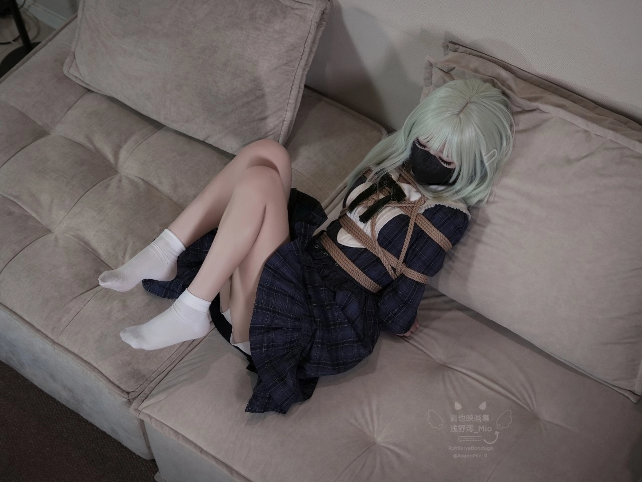 戴着面具和黑色裙子的女人被绑在沙发上。