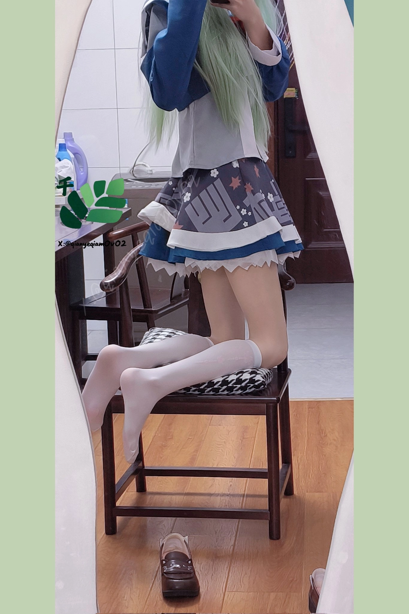 穿着蓝色裙子和白色袜子的女人坐在椅子上。