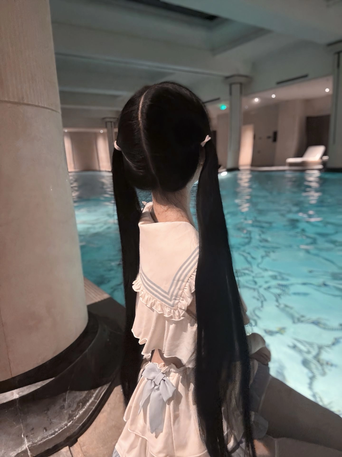 一位穿着兔子面具和水手服的女人在游泳池里。