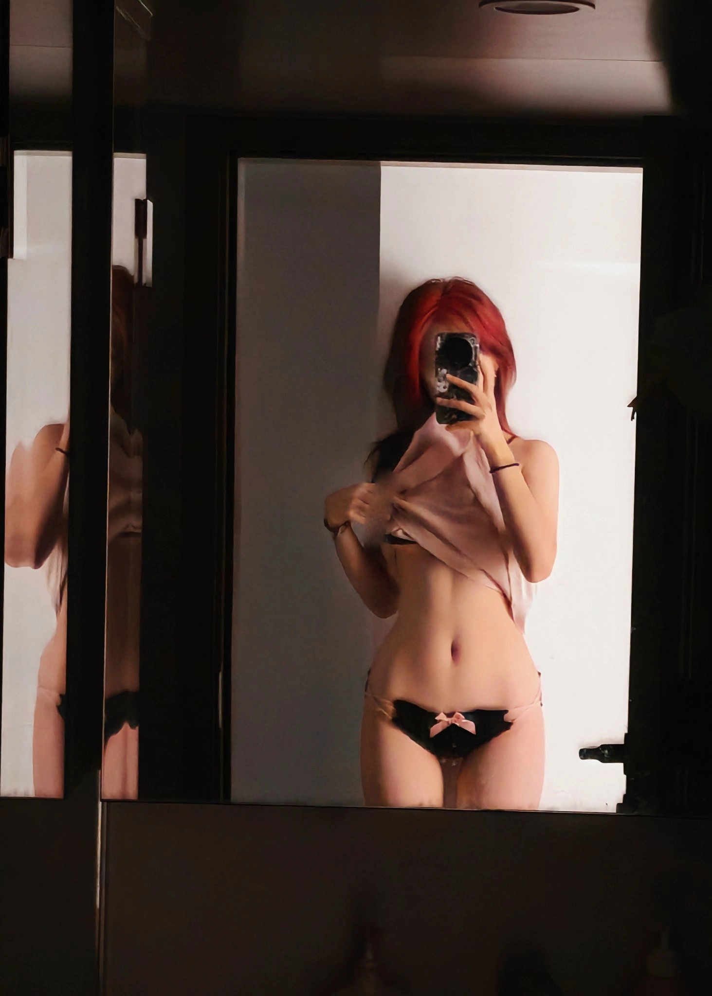 女人在镜子里拍自拍。