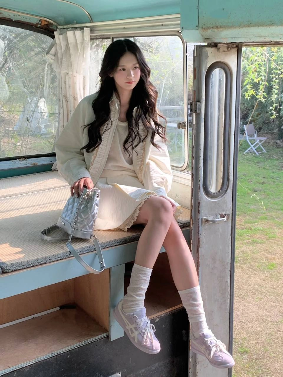女人坐在一个凳子上,戴着一件白色衬衫和白袜子。