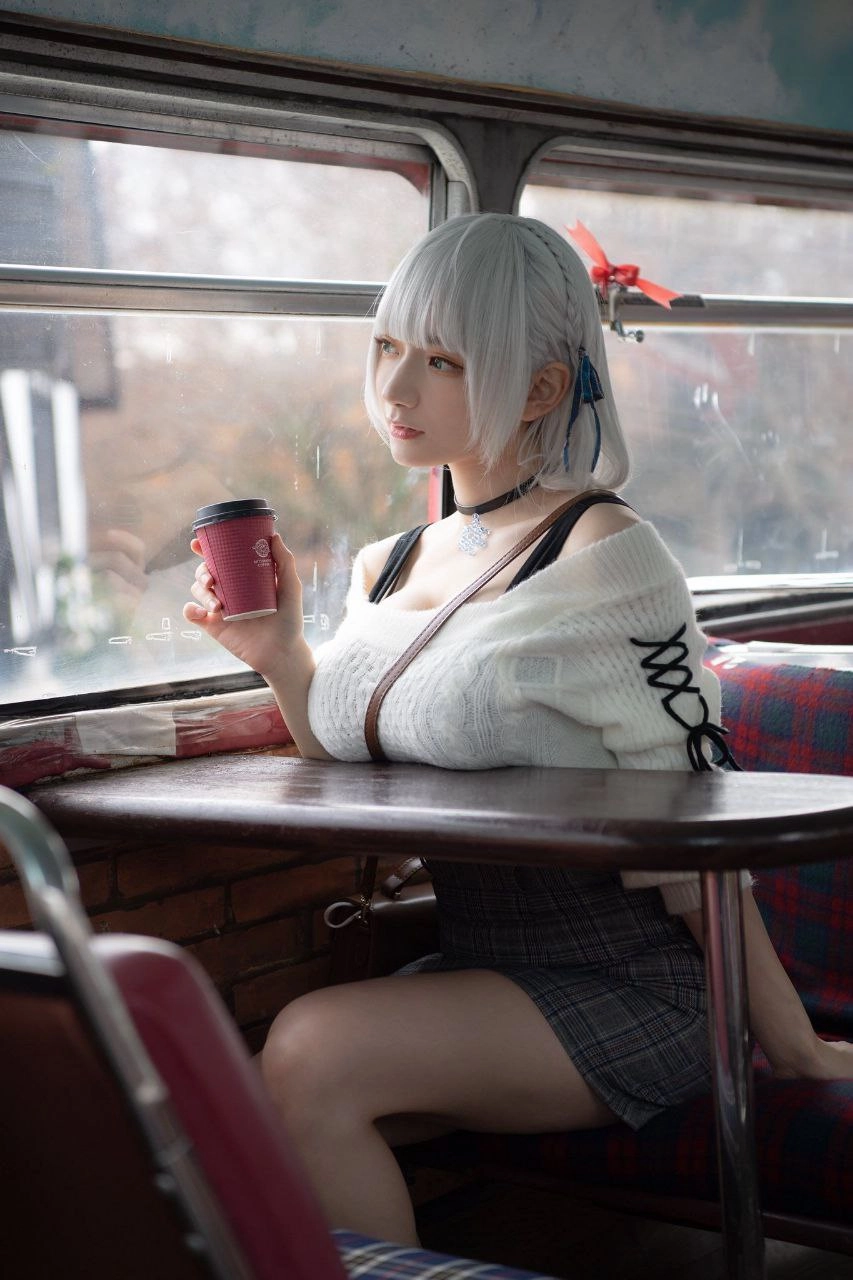 穿着白色衬衫和黑色裙子的女人拿着一杯红色杯子。