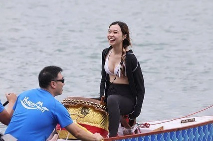 一位穿着蓝色衬衫和帽子的女人坐在椅子上,发出和平的信号。