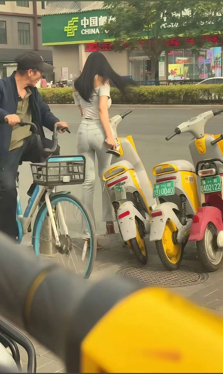 男人和一个女人站在他们的滑板车旁边。