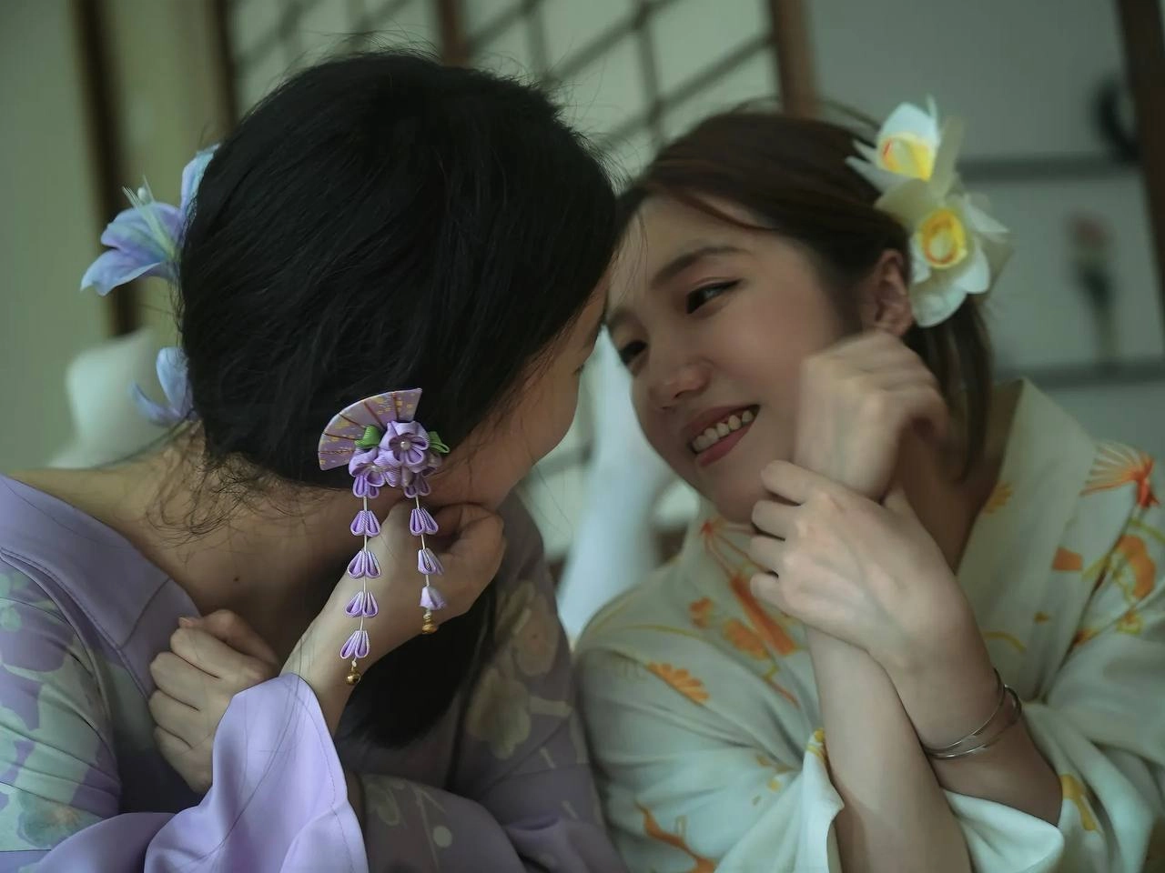 两位女士戴着吉莫诺坐在一张椅子上。