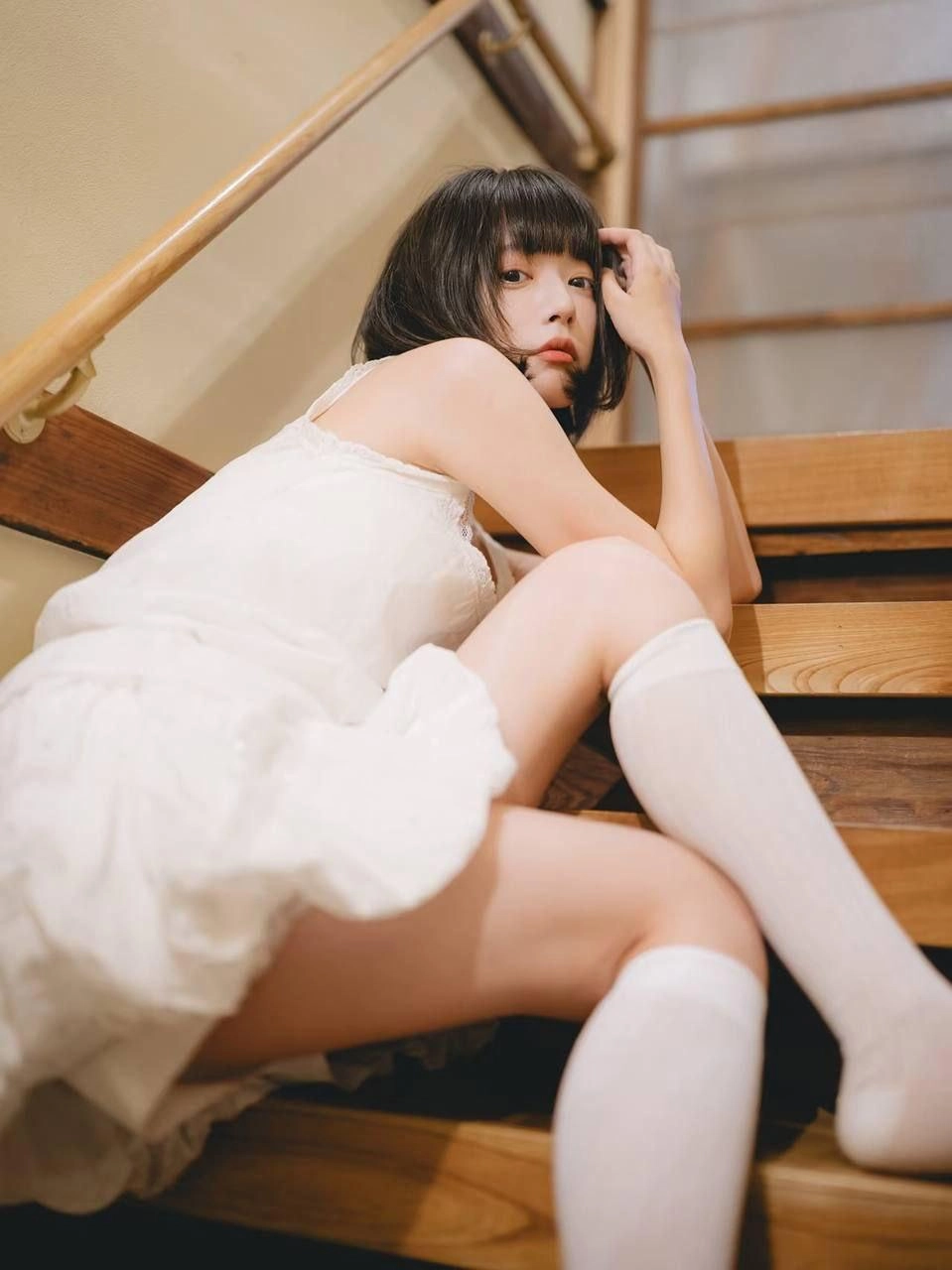 穿着白色衣服的女人坐在楼梯上。
