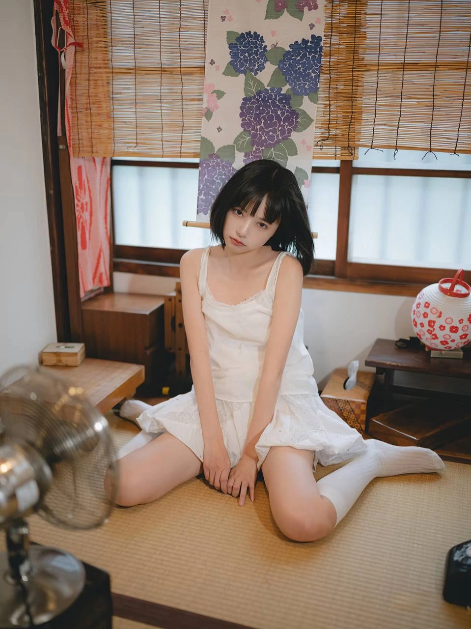 穿着白色衣服的女人坐在楼梯上。