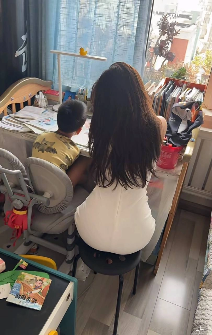 女人和一个孩子坐在一张桌子上。