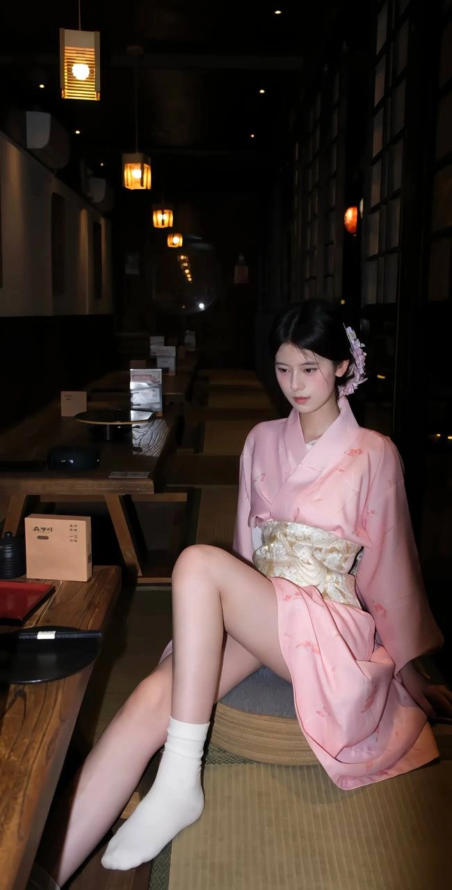 女人穿着粉红色吉莫诺坐在一个凳子上。