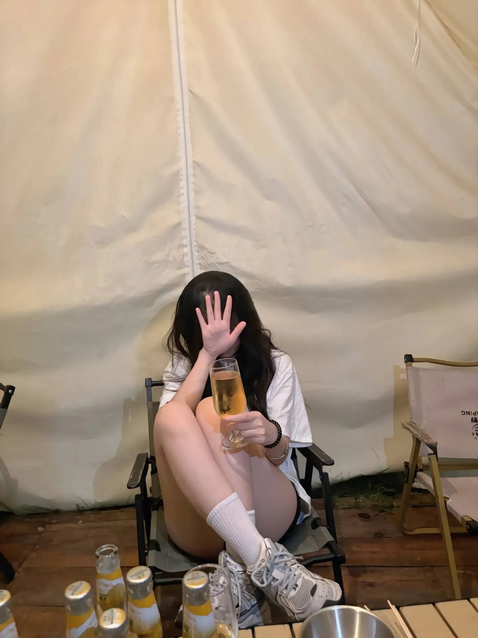 穿着白色衬衫的女人拿着一杯酒。