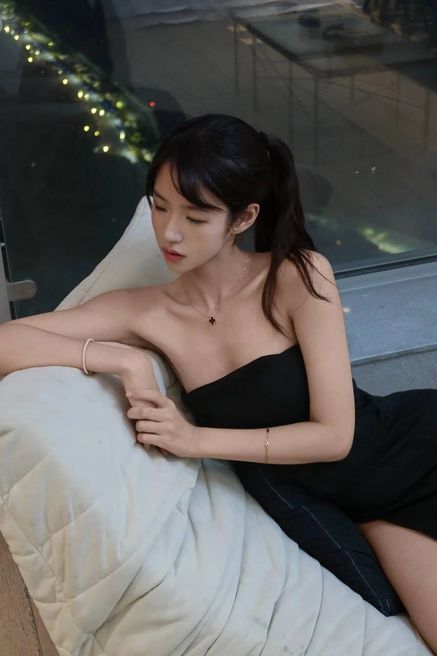 穿着黑色裙子的女人躺在沙发上。